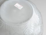a white vase that has a sticker on it