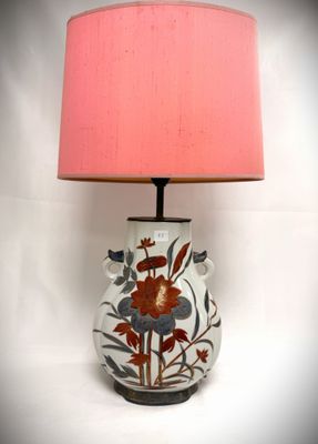 a lamp that is sitting on a table with a pink shade on it