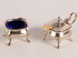 pair of silver plated sugar dishes with blue glass in them