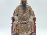 an image of a statue of a man sitting on a red chair