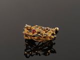 an image of a gold ring with red stones on a black surface