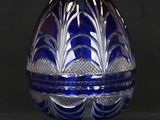 an image of a blue glass egg on a stand