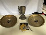 deux bougeoirs en laiton et une coupe en argent posés sur une table