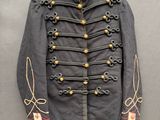 une vieille veste militaire accrochée au mur à côté d'un cintre en bois