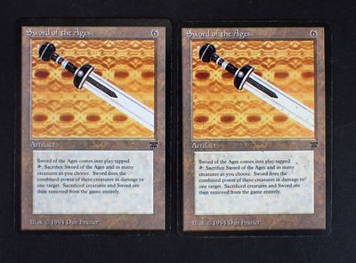these are two cards with a sword on them on a table