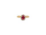 une bague en or sertie d'une pierre rouge entourée de diamants blancs