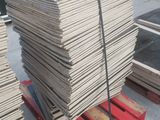 Plusieurs piles de bois sont posées sur une palette dans un entrepôt
