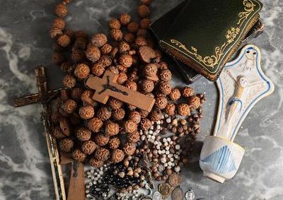 une croix, un chapelet et d'autres objets religieux disposés sur une table