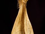 a wooden sculpture of a woman standing on a table
