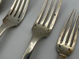 four forks and two spoons sitting on a table