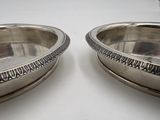 pair of silver plated bowls on a white surface