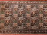 an antique persian rug with a multicolored design on a pink background