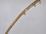 a gold plated dagger with a black handle and a gold plated handle