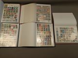 four open books with stamps on them sitting on top of a table