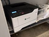 a printer that is sitting on a shelf in a room
