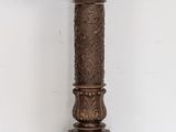 a tall wooden pedestal with carvings on top of it