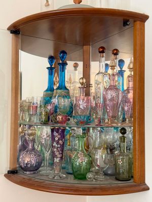 many different colored glass vases in this display case