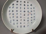 a white plate with blue writing on it on a table