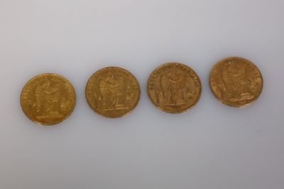 quatre types différents de pièces d'or sur une surface blanche
