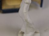 a small figurine of a woman standing in front of a box