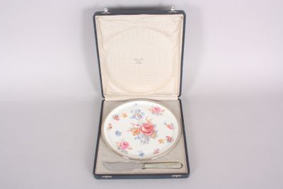 une petite assiette blanche dans un coffret orné de fleurs