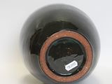 a black vase with a brown rim sitting on a white surface