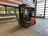 a forklift in the middle of a parking lot in front of a building