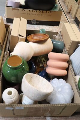 une boîte remplie de vases de toutes sortes posée sur une table
