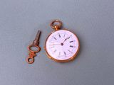 a pocket watch with a key attached to it