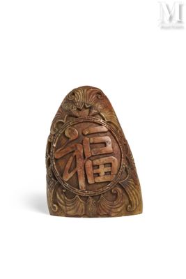 une image représentant une bague en bois sculpté sur laquelle figurent des caractères chinois