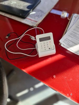 Terminal de paiement SUMUP sur socle avec deux câbles. On y …