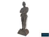 une statue représentant un homme coiffé d'un chapeau et muni d'une canne