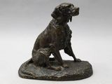 statue en bronze représentant un chien et un chat assis sur un rocher
