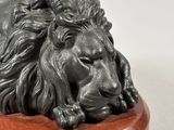 a close up of a statue of a lion on a wooden base