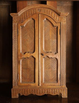 une vieille armoire en bois dans une pièce sombre au sol en parquet