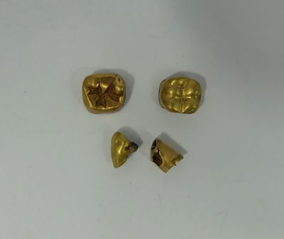 three pieces of gold are shown on a white surface