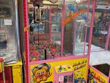 une machine à pinces rose et jaune installée devant d'autres machines