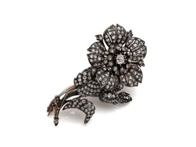 un gros plan d'une broche en forme de fleur sur fond blanc