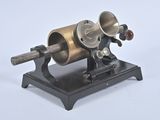 a small machine that is on a stand on a white surface