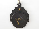 a close up of a clock on a white surface with a black background