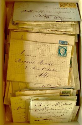 une boîte remplie de vieilles lettres et d'enveloppes posée sur une table