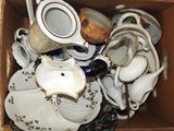 une boîte remplie de tasses à thé et de soucoupes posée par terre