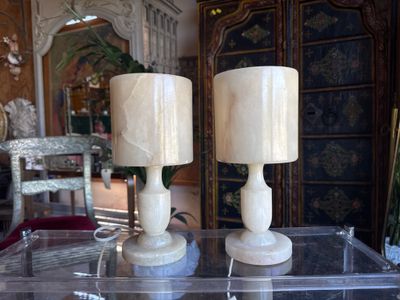 two candles that are sitting on a clear table