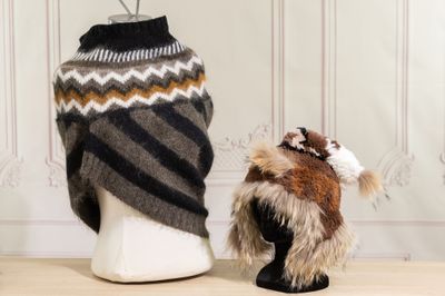 une peluche et un bonnet tricoté posés sur une tête de mannequin