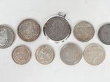 an assortment of coins are arranged in a row on a white surface