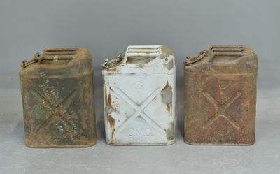 three old metal cans sitting next to each other on top of a table