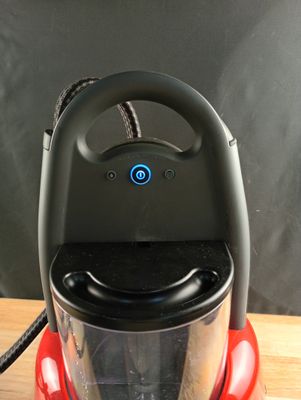 an image of a red vacuum cleaner on a wooden table