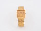 an image of a gold watch on a white surface with a white background