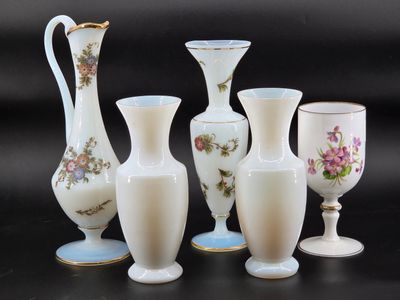 five vases and a goblet sitting on a table