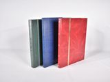 trois livres sont alignés sur une surface blanche